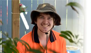 smiling man wearing garden work shirt and work hat