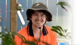 smiling man wearing garden work shirt and work hat