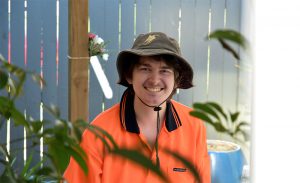 smiling man wearing garden work shirt and work hat