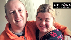 Married couple, with disabilities hugging and smiling