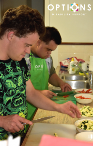 two men chopping vegetables in kitchen learning cooking skills